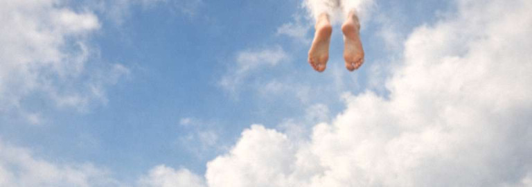 Krankenschwester im Freien, zeigt mit einem Finger auf Füße oben im Himmel