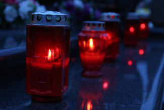 Rote Grablichter auf einem Friedhof