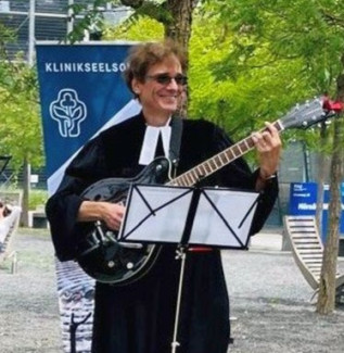 Pfarrer Eunicke mit Gitarre beim Reisesegen.