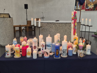 Tauf- und Gedenkkerzen vor dem Altar